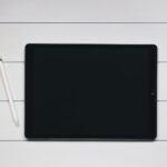 space gray iPad with Apple Pencil with white and black pinstriped background